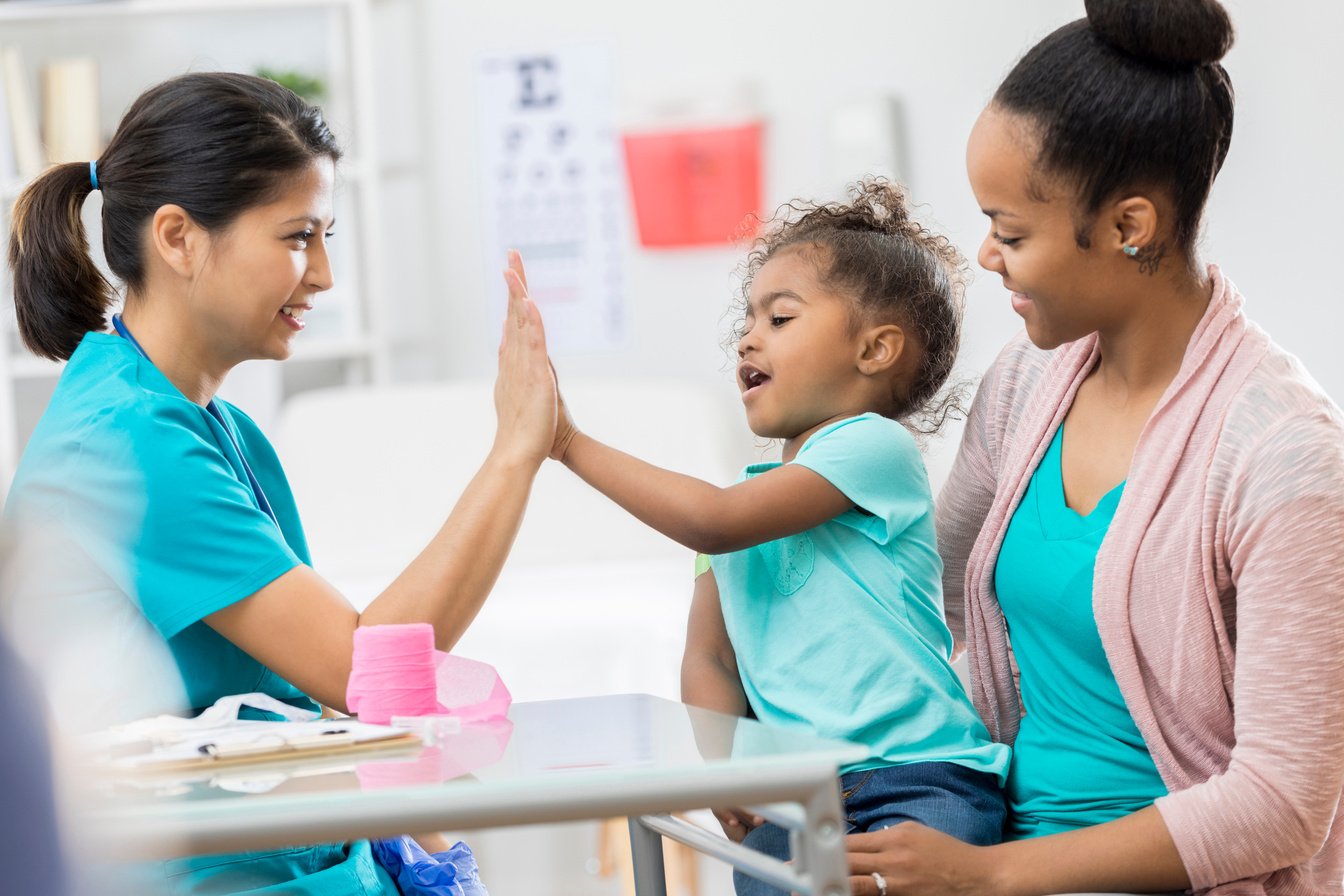 Pediatric nurse gives young patient a high five